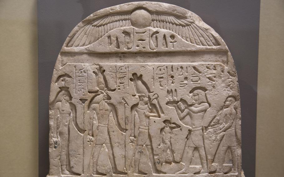 hieroglyphs and drawings of people on a stone